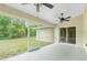A screened lanai with dual ceiling fans overlooking lush greenery at 5611 Ganyard Ave, North Port, FL 34291