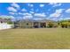 Expansive backyard featuring a screened-in pool area, dining set, and lovely landscaping at 6235 Bixel Ln, Englewood, FL 34224