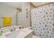 The main bathroom features a vanity with storage and decorative seashells on the shower curtain at 6235 Bixel Ln, Englewood, FL 34224