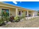 Charming front porch adorned with landscaping, a cozy rocking chair, and colorful accents at 6235 Bixel Ln, Englewood, FL 34224