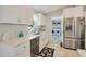 Bright kitchen with white cabinetry, stainless steel appliances, and a view of the laundry room at 6235 Bixel Ln, Englewood, FL 34224