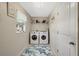 Compact laundry room featuring front loading washer and dryer, shelving, and tiled floors at 6235 Bixel Ln, Englewood, FL 34224