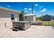 Private backyard with a hot tub on a paved patio, storage sheds, and lush landscaping at 6272 Sooner St, North Port, FL 34287