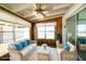 Inviting sunroom with white sofas, wicker furniture, ceiling fan and natural wood paneling at 6272 Sooner St, North Port, FL 34287