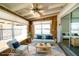 Cozy sunroom with light blue sofas and chairs, natural wood paneling, and ceiling fan at 6272 Sooner St, North Port, FL 34287