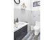Nautical themed bathroom featuring a white vanity with a black cabinet, gold faucet, toilet, and decorative accents at 7200 Riverside Dr, Punta Gorda, FL 33982
