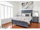 This bedroom features a gray wood bed frame, beautiful light and airy window shutters, and warm hardwood floors at 7200 Riverside Dr, Punta Gorda, FL 33982