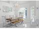 Bright dining room features hardwood table and bench, white chairs, modern lighting, and large windows at 7200 Riverside Dr, Punta Gorda, FL 33982