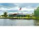 Waterfront home featuring a private dock with boat lift, lush green lawn, and a picturesque view of the calm water at 7200 Riverside Dr, Punta Gorda, FL 33982