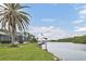 Waterfront home with a screened-in patio, lush green lawn, and private dock with boat lift, offering serene water views at 7200 Riverside Dr, Punta Gorda, FL 33982