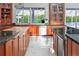 Gourmet kitchen boasts an island, stainless steel appliances, cherry wood cabinets, and water views at 7200 Riverside Dr, Punta Gorda, FL 33982