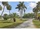 Wide driveway leading to lush, grassy property with mature palm trees at 7200 Riverside Dr, Punta Gorda, FL 33982