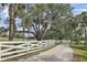 Picturesque gravel driveway leading through a property lined by mature trees at 7200 Riverside Dr, Punta Gorda, FL 33982