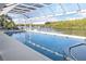 Enclosed pool with screened enclosure overlooking a private boat dock on the water and lush green trees at 7200 Riverside Dr, Punta Gorda, FL 33982