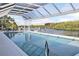 Enclosed pool with screened enclosure overlooking a private boat dock on the water and lush green trees at 7200 Riverside Dr, Punta Gorda, FL 33982
