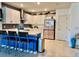 Open concept kitchen with white cabinetry, blue island, stylish barstools and tile flooring at 7232 W Lenox Cir, Punta Gorda, FL 33950