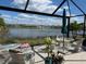 The screened-in patio overlooks a scenic lake view complete with outdoor furniture and a patio umbrella at 7232 W Lenox Cir, Punta Gorda, FL 33950