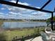 Relaxing screened-in lanai view features a serene lake with fountain and lush green landscaping at 7232 W Lenox Cir, Punta Gorda, FL 33950