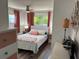 Bright bedroom with a comfortable bed, stylish linens, matching nightstands and salmon color decor at 805 S Green Cir, Venice, FL 34285