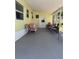 Inviting covered porch with comfortable seating, perfect for relaxing and entertaining guests outdoors at 805 S Green Cir, Venice, FL 34285