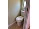 Bathroom featuring a standard white toilet with a small window above, and light wood-look flooring at 805 S Green Cir, Venice, FL 34285