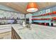 Spacious kitchen island with a large sink, pendant lighting, and face-themed wallpaper at 810 Napoli Ln, Punta Gorda, FL 33950