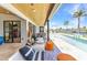 Covered patio with travertine floors, outdoor seating, and views of the canal-front pool and backyard at 810 Napoli Ln, Punta Gorda, FL 33950