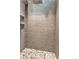 A tiled shower stall features a pebble floor, mosaic tile accents, and modern geometric tiling at 810 Napoli Ln, Punta Gorda, FL 33950