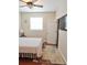 Cozy bedroom with hardwood floors, neutral walls, a ceiling fan, and a window with natural light at 8233 Burwell Cir, Port Charlotte, FL 33981