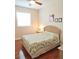 Bright bedroom with hardwood floors, neutral walls, ceiling fan, and a well-lit bedside table at 8233 Burwell Cir, Port Charlotte, FL 33981