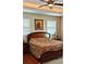 Bedroom featuring a large bed, hardwood floors, neutral walls, and tray ceiling at 8233 Burwell Cir, Port Charlotte, FL 33981