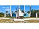 Community of South Gulf Cove entrance featuring lush landscaping, water birds, and blue skies at 8233 Burwell Cir, Port Charlotte, FL 33981