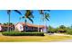 One-story home with attached garage, surrounded by well-maintained greenery and swaying palm trees at 8233 Burwell Cir, Port Charlotte, FL 33981