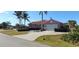 Charming pink single-story home with a well-manicured lawn and paver driveway at 8233 Burwell Cir, Port Charlotte, FL 33981