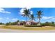 Charming pink single-story home with a well-manicured lawn and several mature palm trees at 8233 Burwell Cir, Port Charlotte, FL 33981