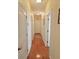 Hallway with hardwood floors that leads to multiple rooms and features neutral walls and white trim at 8233 Burwell Cir, Port Charlotte, FL 33981