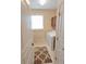 Bright laundry room featuring white washer and dryer units, storage cabinets, and tiled flooring at 8233 Burwell Cir, Port Charlotte, FL 33981