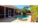 Backyard pool and spa with screened patio, outdoor kitchen, and lush tropical landscaping at 8233 Burwell Cir, Port Charlotte, FL 33981