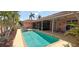 An inviting backyard features a refreshing pool, spa, covered lanai, and tropical landscaping at 8233 Burwell Cir, Port Charlotte, FL 33981