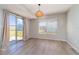 Bright dining room featuring hardwood floors, a modern light fixture, and sliding glass doors to the backyard at 8238 San Jacinto Ave, North Port, FL 34287