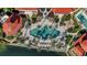 Aerial view features a uniquely shaped pool with chairs and palm trees at 98 Vivante Blvd # 9834, Punta Gorda, FL 33950