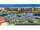 Aerial view showcases tennis courts, lush landscaping, and surrounding waterway at 98 Vivante Blvd # 9834, Punta Gorda, FL 33950