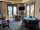 The card room features plenty of tables and chairs, a television and natural light through french doors at 98 Vivante Blvd # 9834, Punta Gorda, FL 33950