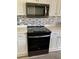 Modern kitchen featuring a black oven and microwave with stainless steel accents and mosaic backsplash at 98 Vivante Blvd # 9834, Punta Gorda, FL 33950