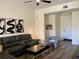 Inviting living room with dark laminate floors, black leather sofa, and sleek black coffee table at 98 Vivante Blvd # 9834, Punta Gorda, FL 33950