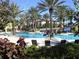 Sparkling community pool surrounded by lush tropical landscaping and lounge chairs for relaxation at 98 Vivante Blvd # 9834, Punta Gorda, FL 33950