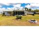 Large backyard with lush green grass, landscaping, and a boat at 11105 Pendleton Ave, Englewood, FL 34224