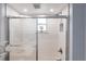 Modern bathroom shower stall with glass door and decorative tile in neutral tones at 11105 Pendleton Ave, Englewood, FL 34224
