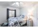 Cozy bedroom with floral bedding, ceiling fan, and natural light from the window at 11105 Pendleton Ave, Englewood, FL 34224