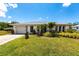 Charming single-story home featuring a lush green lawn, mature landscaping, and an attached one car garage at 11105 Pendleton Ave, Englewood, FL 34224